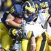 Michigan running back Thomas Rawls attempts to move the ball around Iowa defensive back Tanner Miller in the second quarter at Michigan Stadium. Melanie Maxwell I AnnArbor.com